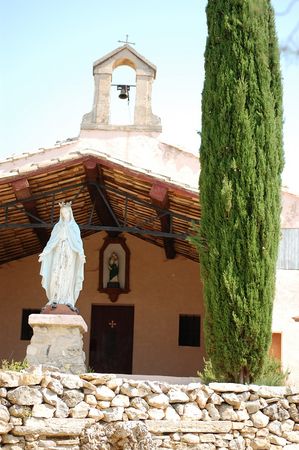 façade de la chapelle,le cyprès s'élance aux cotées de la vierge
